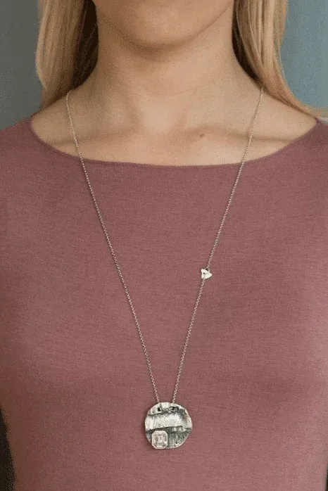 round silver pendant with crystal